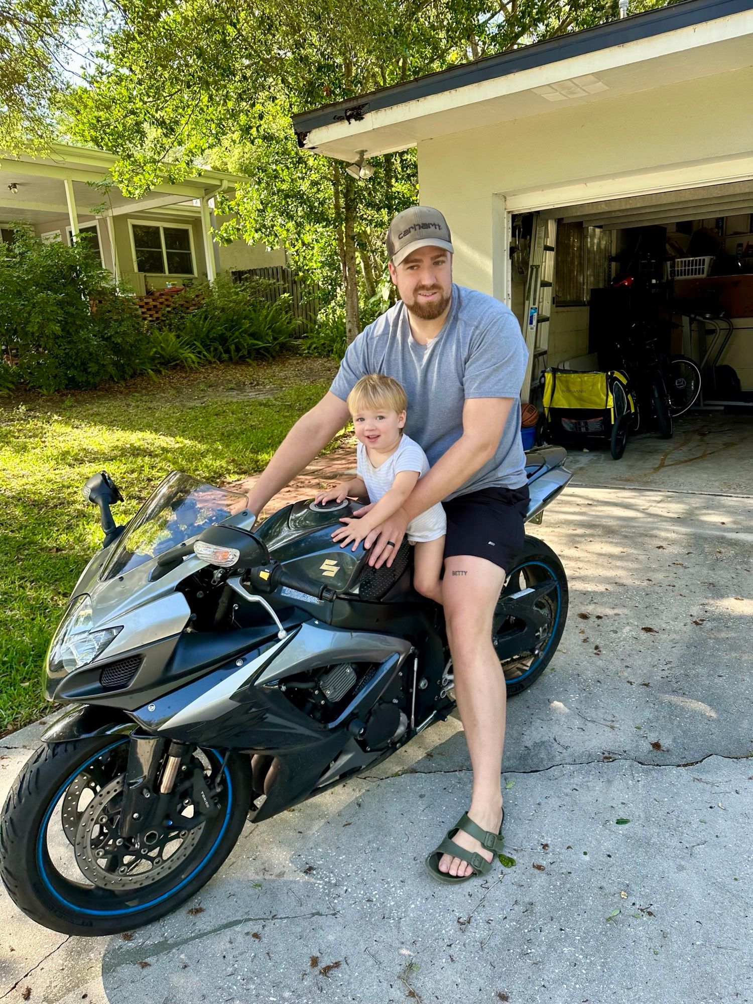 Mike sitting on his motorcycle with his young son